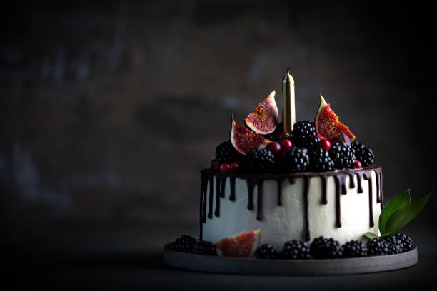 istock Cake decorated blackberries and figs with candle 1289578977