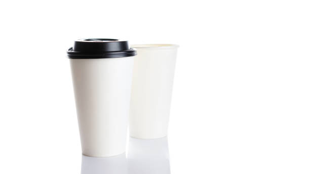 istock White paper cup for hot coffee with black lid isolated on white background. Takeaway blank small tea cup for your design text or banner of brand. 1289579197