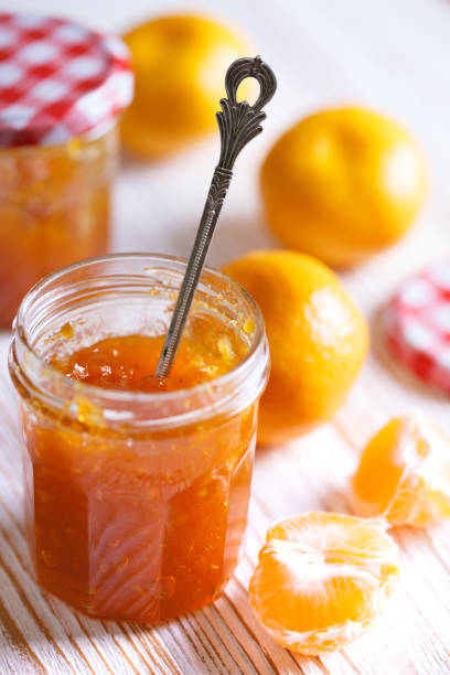 geleia de mandarim em potes de vidro em um fundo de madeira. vida morta"n - gelatin dessert orange fruit marmalade - fotografias e filmes do acervo