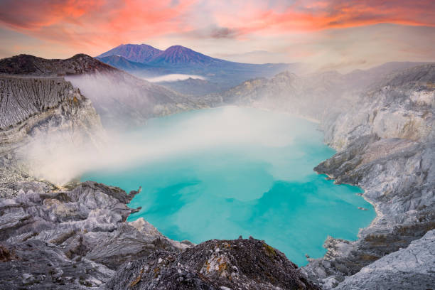 View from above, stunning aerial view of the Kawah Ijen volcano complex at sunset with the blue acid lake and some clouds of toxic gases raising from a sulfur deposit. East Java, Indonesia. View from above, stunning aerial view of the Kawah Ijen volcano complex at sunset with the blue acid lake and some clouds of toxic gases raising from a sulfur deposit. East Java, Indonesia. erupting photos stock pictures, royalty-free photos & images