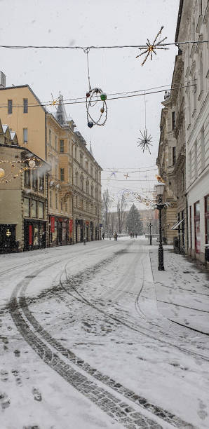 einige leute in der verschneiten altstadt von ljubljana - ljubljana december winter christmas stock-fotos und bilder