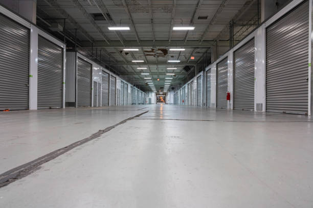 istock Wide Storage warehouse corridor interior. Metal garage doors with locks. Low angle shot 1289580845