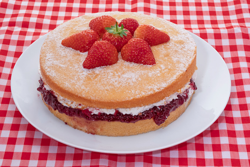 A Victoria sponge cake decorated with fresh strawberries