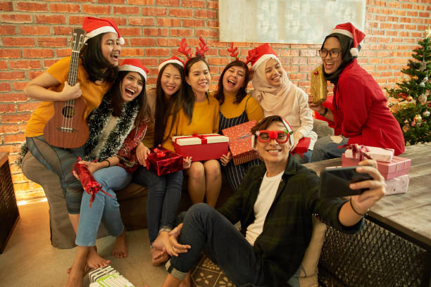 若い笑顔アジアの男女、20〜25歳、サンタの帽子はクリスマスと新年のパーティーのためのメガネをクリンク - 35 40 years women female smiling ストックフォトと画像
