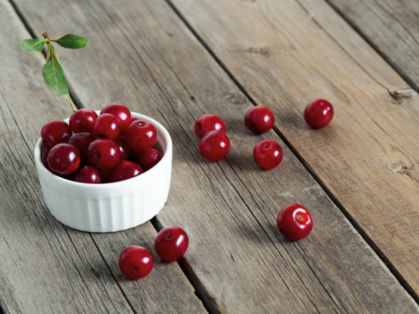 istock Red ripe cherries on rustic weathered wooden table. 1289593071