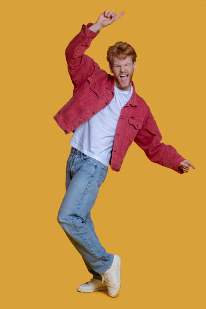 istock Red-haired bearded young man in red jacket feeling excited 1289594176