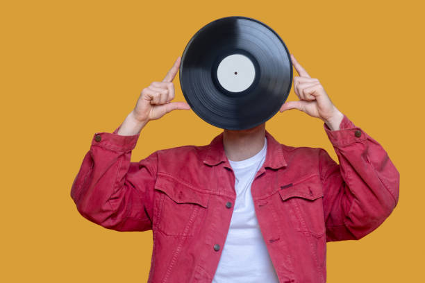istock Red-haired bearded young guy in red jacket with a record 1289594200