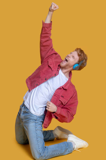 istock Young ginger man listening to music and feeling entertained 1289594375