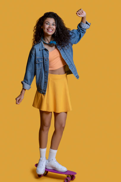 istock Pretty dark-haired young girl on a skateboard 1289594576