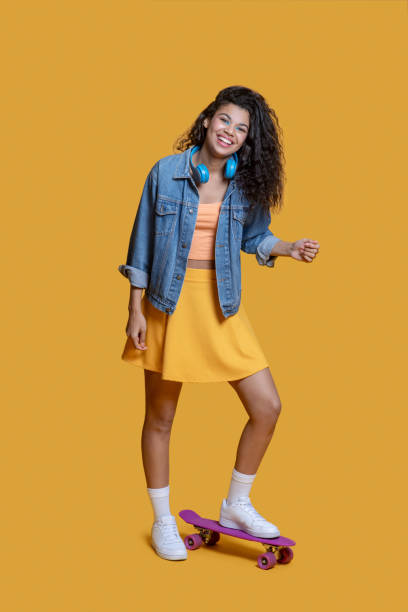 istock Pretty dark-haired young girl on a skateboard 1289594580