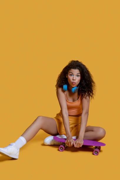 istock Pretty dark-haired young girl with a skateboard looking sad 1289594589
