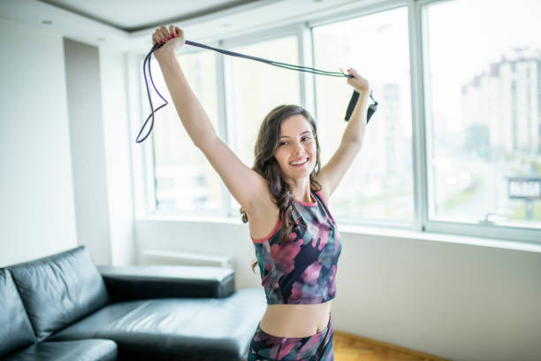 istock Fit woman stretching with jumping rope at home 1289597566