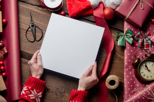 istock Woman hold mockup board on wooden table in wrapping time 1289599639
