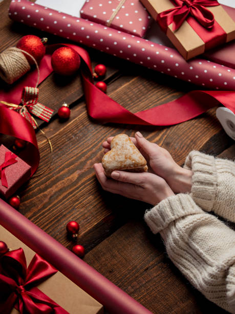 istock Woman hold heart shape cookie on wooden table in wrapping time 1289599708