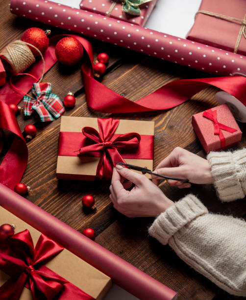 istock Woman wrapping gift on wooden table 1289599734