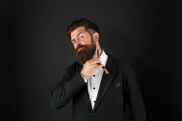 Good beard needs good barber. Bearded man hold beard grooming tool. Businessman shave beard with razor. Beard shaving and styling. Facial hair. Barbering. Barbershop