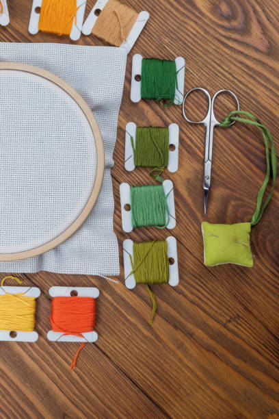 istock Cross stitch hoop with stretched canvas on wooden background with copyspace 1289605614