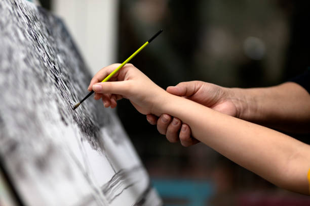 istock Father is encouraging her son while he is painting 1289610639