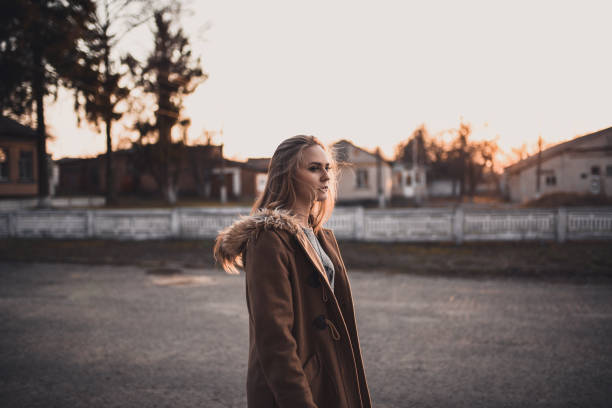 istock Woman in a brown coat On the Sunset 1289610719