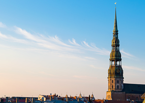 Symbol of Riga, old clock on medieval church tower among roofs ancient buildings with European architecture