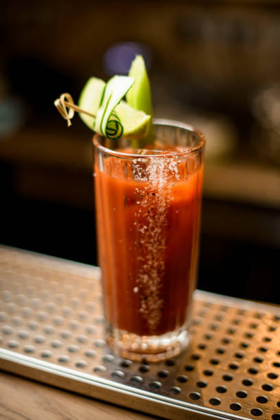 verre de cocktail garni de tranches de légumes frais se dresse sur le comptoir du bar - tomato juice drink celery juice photos et images de collection