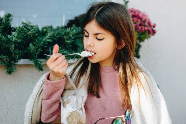 Girl eating dessert outdoors stock photo