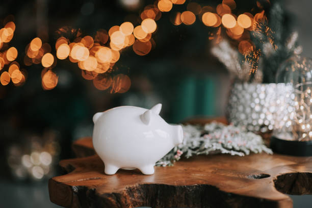 piggy bank in festive new year atmosphere of scenery. magical bokeh with christmas tree and bright lights. - bônus imagens e fotografias de stock