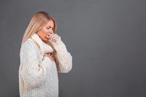 Young beautiful woman with wearing casual sweater feeling unwell and coughing as symptom for cold or bronchitis. Health care concept.