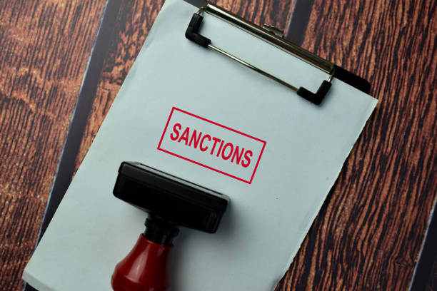 close up red handle rubber stamper and text sanctions isolated on white background. - poder imagens e fotografias de stock