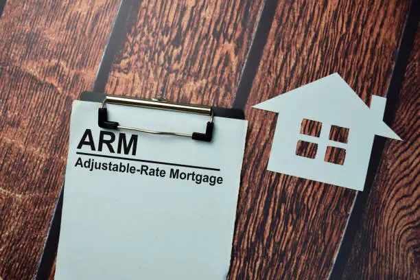 Photo of ARM - Adjustable-Rate Mortgage write on a paperwork isolated on office desk.