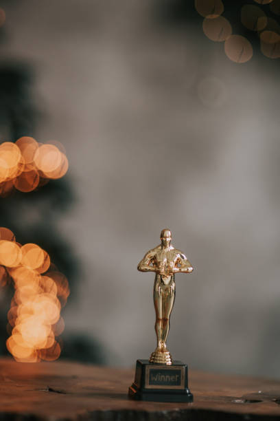 美しいボケの背景に勝者の金色の小像 - oscar statuette ストックフォトと画像