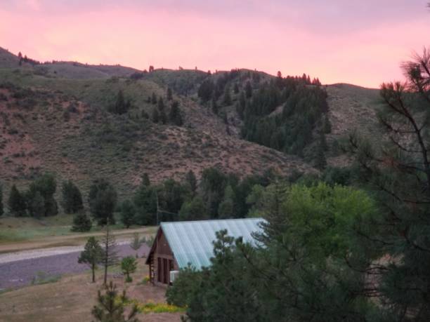 istock Mountain cabin with river and sunset 1289621559