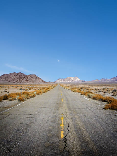 istock Abandoned rundown road, moon and distant mountains in remote west Nevada 1289622551