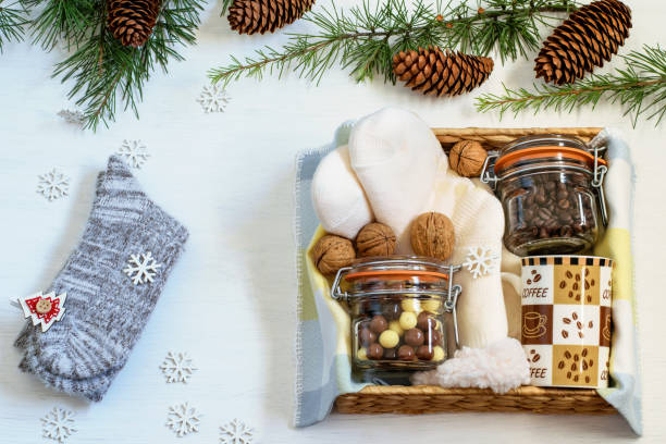 istock Handmade care packaged gift box with coffee beans, coffee cup, chocolate and warm socks. New Year background. Eco friendly gift basket for Christmas or New Year. 1289623870