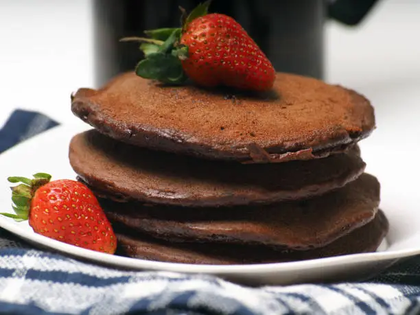 Close up shoot of stacked brown chocolate flafor pancake on an isolated white background