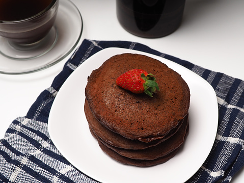 Close up shoot of stacked brown chocolate flafor pancake on an isolated white background