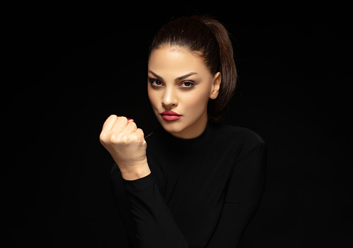 Angry young woman clenched with her fist.