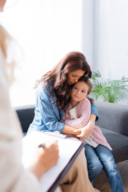 istock worried mother hugging daughter while visiting psychologist 1289637455