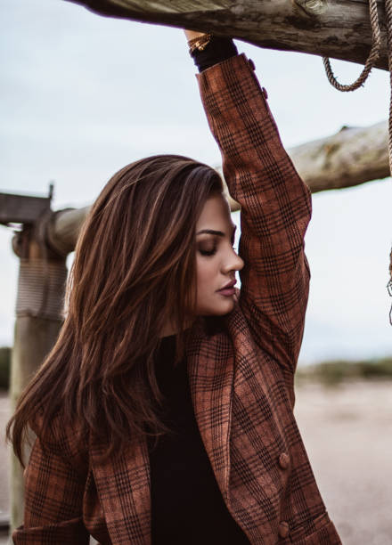 Side view of woman in a plaid jacket in a tree structure.
