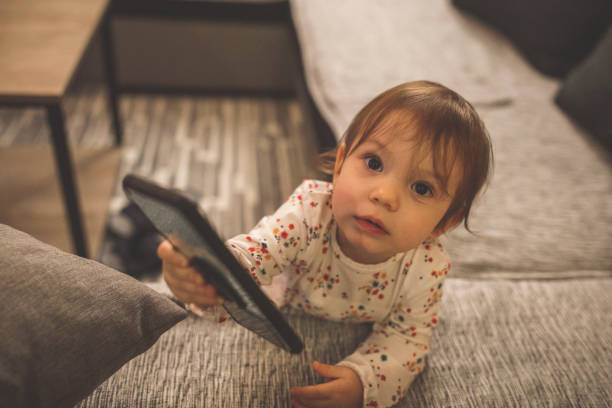 istock Baby girl playing with smart phone 1289639708