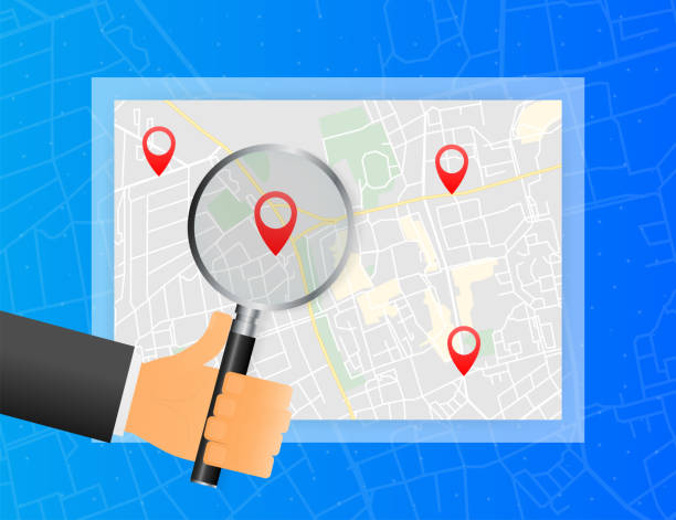 istock Hand holds magnifying glass in searching markers on maps on blue background. Vector illustration. 1289651283