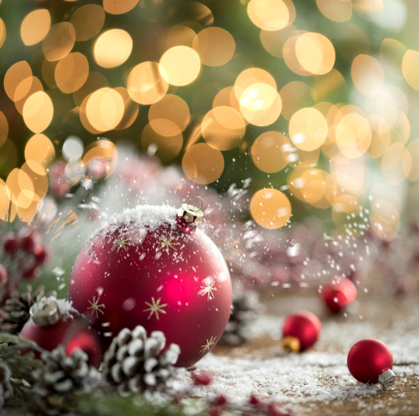 istock Christmas Baubles with Snow in front of a Christmas Tree 1289652180