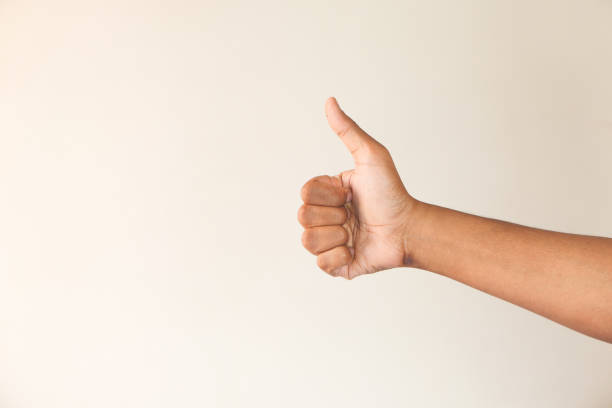 istock man's hand hand showing a thumb-up on white wall 1289652236