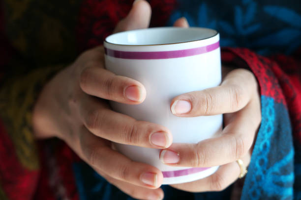 istock Close up of women's hand holding coffee mug 1289652301