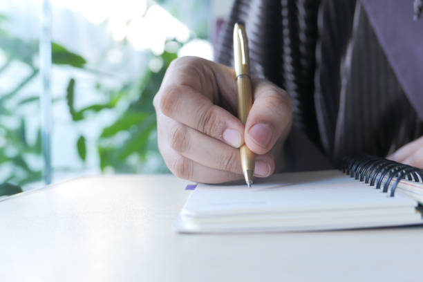 istock Close up of women hand writing on notepad. 1289652317