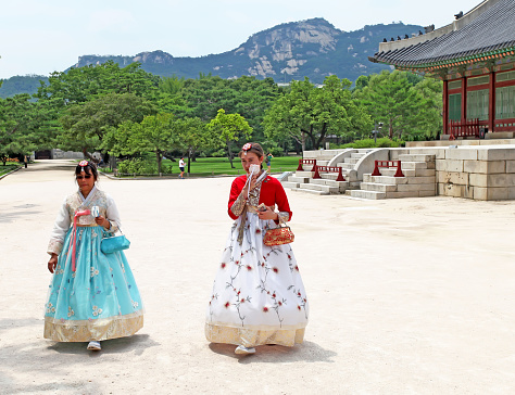 Seoul, South Korea - July 4, 2018. The Gyeongbokgung Palace in Seoul. Visitors dressed in traditional Korean Hanbok costumes.