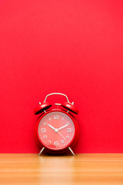 istock Red alarm clock on the wooden table 1289657947