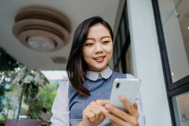 istock Young asian woman using smartphone in a cafe 1289659537