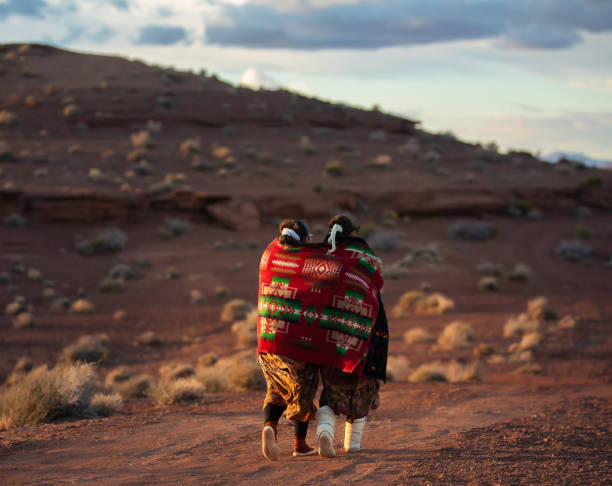 navajo-frauen schützen sich gegenseitig mit einer traditionellen decke vor der k�älte - navajo american culture indigenous culture women stock-fotos und bilder