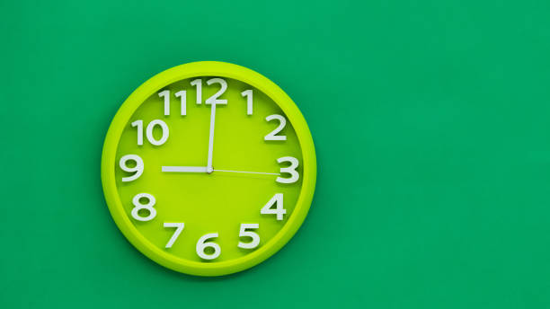 istock Green wall clock on green background 1289661726